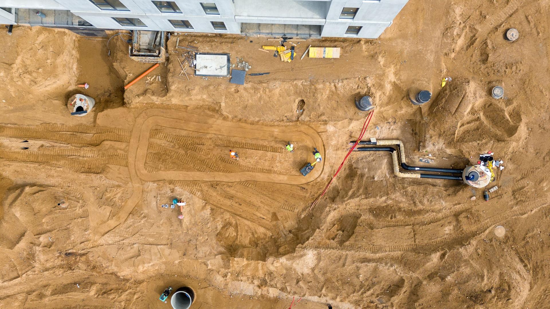 Aerial View of Construction Site with Groundwork and Pipe Installation