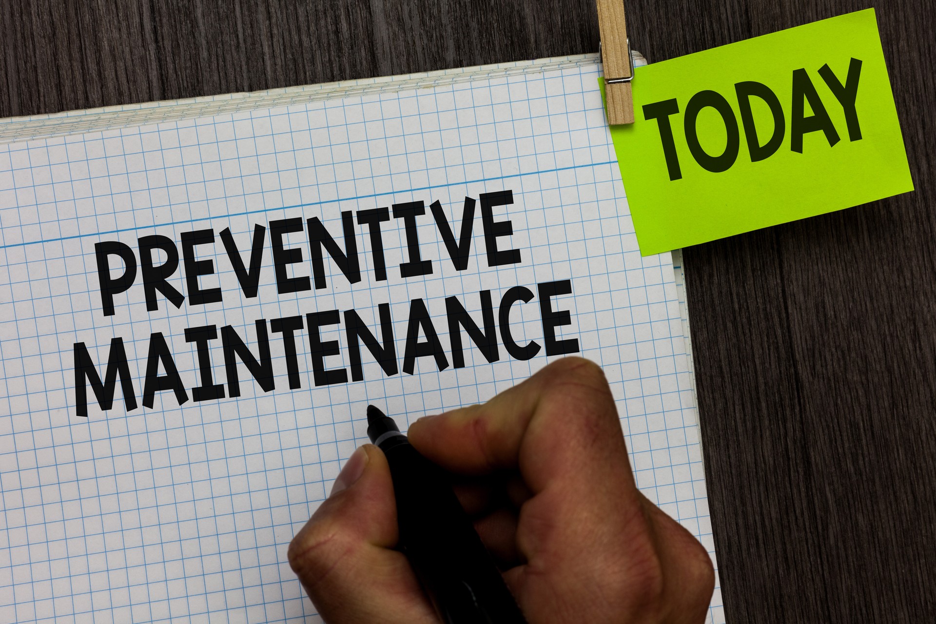 Word writing text Preventive Maintenance. Business concept for Avoid Breakdown done while machine still working Man holding marker notebook clothespin hold reminder wooden background.